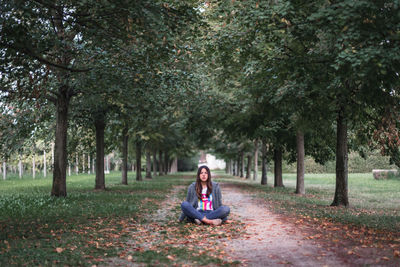 Portrait of woman sitting in park during autumn