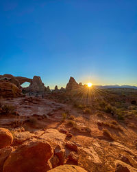 Scenic view of rock formations at arches national park against blue sky