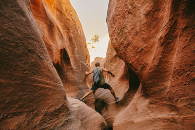 Young man exploring narrow slot canyons in escalante, during summer