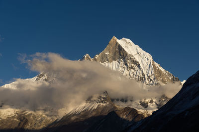 Scenic view of snowcapped mountains against blue sky