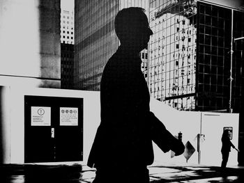 Rear view of silhouette people standing in city