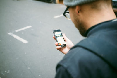 Mid adult man using phone on street