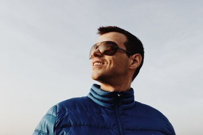 Smiling man wearing sunglasses against sky