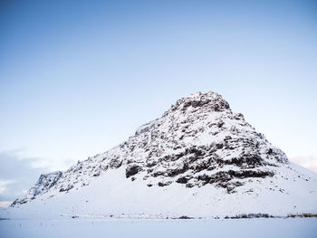 Low angle view of snowcapped mountain against clear sky