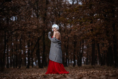 Full length of woman standing in forest