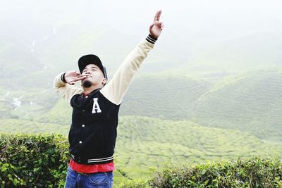 Man with arms raised while standing on mountain