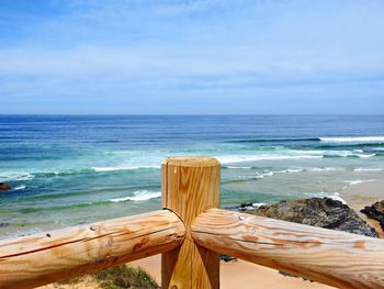 Close-up of wooden posts on beach against sky