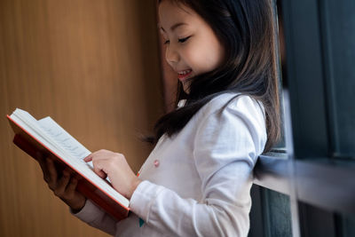 Side view of girl reading book