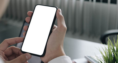 Close-up of hand holding mobile phone