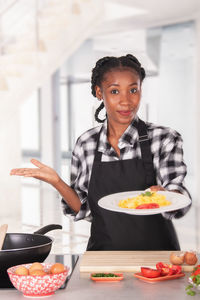 Portrait of woman holding ice cream at home