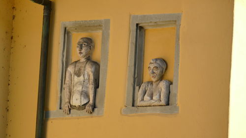 Statue against yellow wall