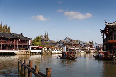 Boats in river against buildings