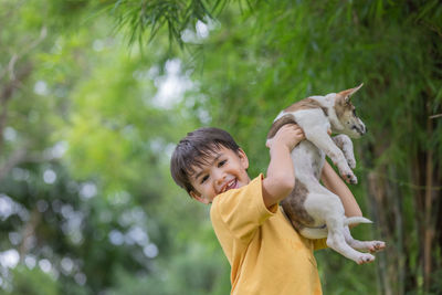 Boy standing at park with dog
