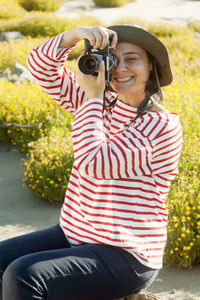 Smiling mature woman photographing through camera