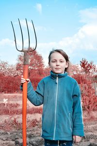 Portrait of boy standing against sky