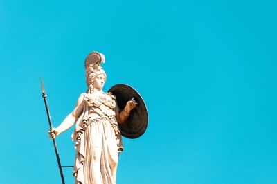 Low angle view of statue against blue sky