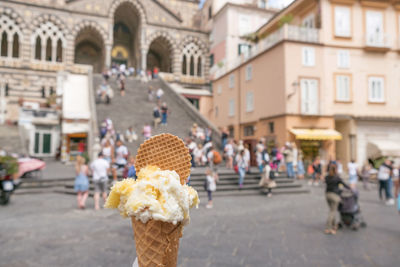 Ice cream cone against people in city