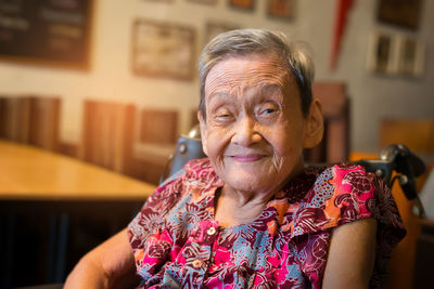 Portrait of woman sitting on chair at home