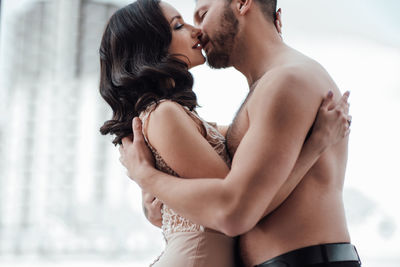 Midsection of couple kissing