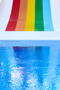 Multi colored swimming pool by sea against sky