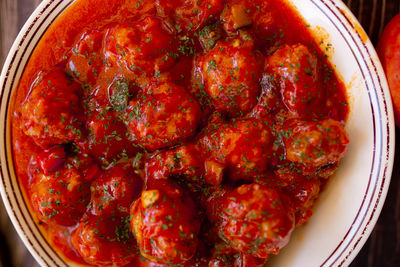 Closeup meatballs in sweet and sour tomato sauce. top view.