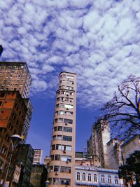 Low angle view of buildings against cloudy sky