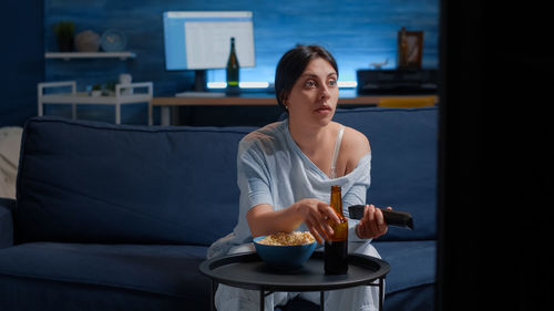 Portrait of young woman drinking coffee at home