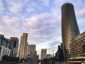 Low angle view of buildings against cloudy sky