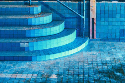 Stack of stones by swimming pool against building