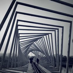 People walking on bridge against sky