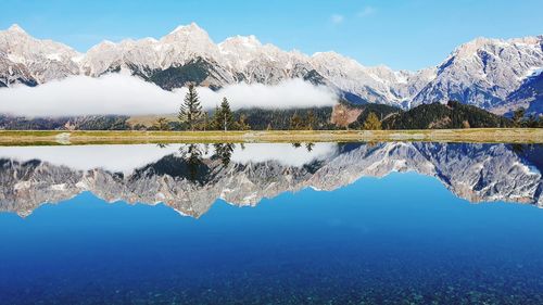 Scenic view of lake by mountains against sky