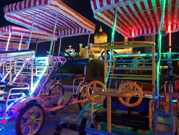 Illuminated ferris wheel at amusement park at night