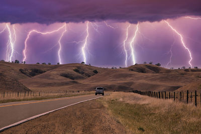 Lightning over road against sky