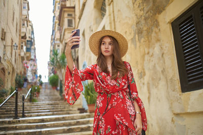 Portrait of woman standing against wall