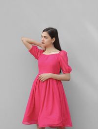 Young woman standing against white background