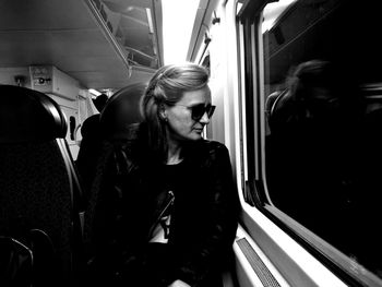 Young woman wearing sunglasses traveling in train