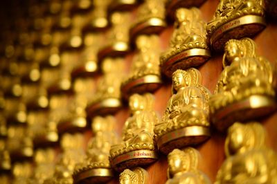 Full frame shot of golden buddha statues on wall