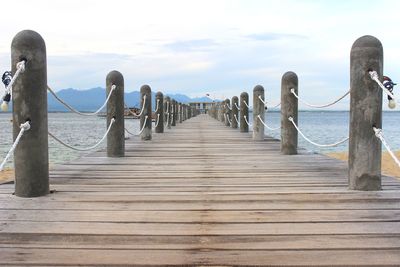 Wooden pier on sea against sky