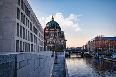 Canal amidst buildings against sky in city