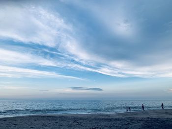 People at beach against sky