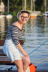 Attractive woman posing on the marina at a sunny summer day at the river