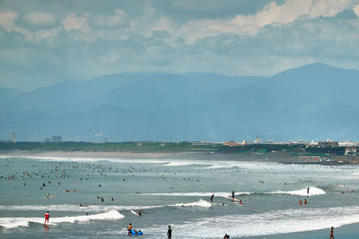 Group of people on beach against sky