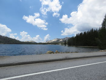 Scenic view of road by lake against sky