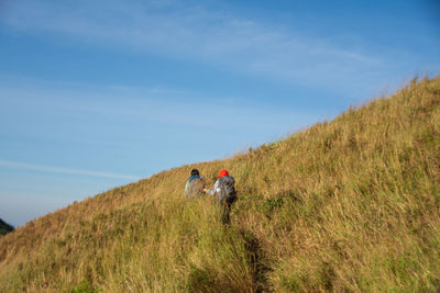 People walking on mountain against sky