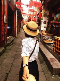 Rear view of woman standing on street in city