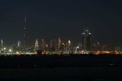 Illuminated city against sky at night