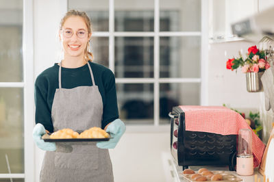 Portrait of a smiling young woman holding food