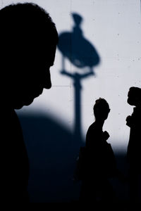 Side view silhouettes of three people crossing paths