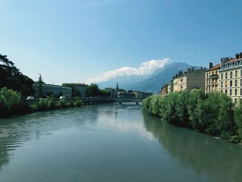 River amidst buildings against blue sky