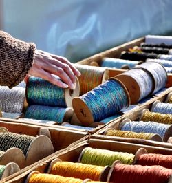 Cropped hand of woman choosing spool in market